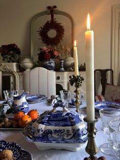 a dining room table with plates and candles