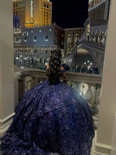 a woman in a blue dress looking at the las vegas strip