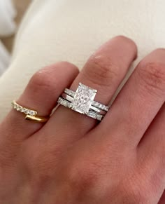 a woman's hand with two rings on it and a diamond ring in the middle