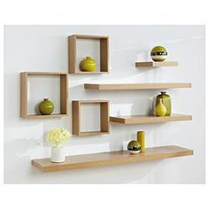 three wooden shelves on the wall with vases and apples in them, one is empty