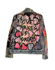 a jacket with graffiti written on it and the words love makes us great in pink, green