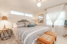 a bed room with a neatly made bed and a small tv on the side table