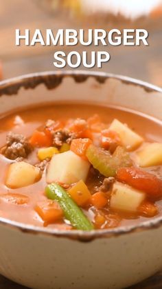 a close up of a bowl of soup on a table with the words hamburger soup above it