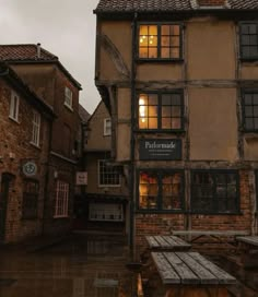 an old building with tables and benches in the rain