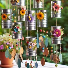 tin can wind catchers with flowers and leaves hanging from them