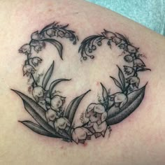 a heart shaped tattoo with flowers on it