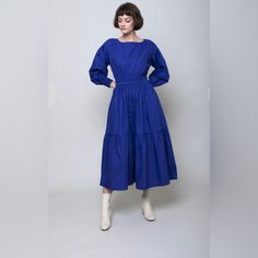 The Estrella Dress Has Smocked Elastic At The Waist And Cuffs To Give This Laid-Back Midi An Easy, Feminine Fit. Cut From Soft Cotton Poplin, The Dress Features A Boat Neckline With Keyhole Closure, Single Tier In Skirt, Dolman Sleeve With Drop Shoulder, Elasticated Smocking At The Waist And Cuffs. Model Is 5'8" And Is Wearing A Size Extra Small. Spring Blue Midi Dress With Elastic Sleeves, Blue Knee-length Midi Dress With Smocked Back, Blue Workwear Dress With Elastic Sleeves, Blue Midi Dress With Gathered Sleeves For Daywear, Blue Midi Dress With Gathered Sleeves For Work, Blue Midi Dress With Gathered Sleeves For Brunch, Blue Knee-length Smocked Dress, Blue Knee-length Dresses With Smocked Cuffs, Blue Knee-length Dress With Smocked Cuffs