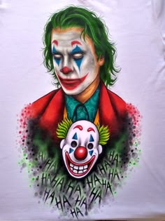 a white t - shirt with a drawing of the joker and clown face on it