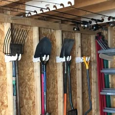 the tools are hanging on the wall in the garage