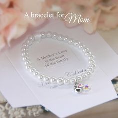 Keepsake gift bracelet for momWhite pearl beads and dainty heart charmFinished with iridescent beadBeautifully presented, boxed with sentiment A Mother's love is the heart of the familyHeirloom CollectionMade in the USA Mother's Day Heart Charm Bracelet Gift For Mom, Elegant Heart-shaped Bracelet For Mom, Hypoallergenic Pearl Bracelet For Mother's Day, White Heart Bracelet For Mother's Day Gift, Heart Charm Bracelet For Wedding And Mother's Day, Heart Charm Bracelets For Wedding And Mother's Day, Elegant White Charm Bracelet For Mother's Day, Hypoallergenic Pearl Bracelets For Mother's Day, Mother's Day Gift Beaded Bracelet With Heart Charm