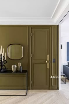 a living room with green walls and white trim on the door, candles in front of it