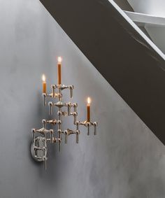 a wall mounted candle holder with candles on it