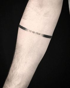 a man with a tattoo on his arm that reads 10 04 1932 and has a black ribbon around the wrist