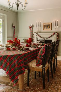 the table is set for christmas dinner with red and green plaid cloths on it