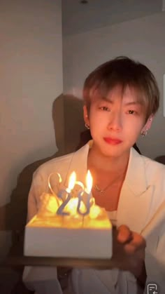 a woman holding a cake with candles in it