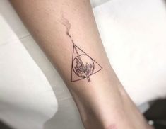 a woman's arm with a tattoo on it that has a triangle in the middle