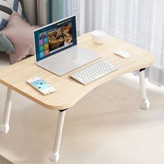 a laptop computer sitting on top of a wooden desk next to a keyboard and mouse