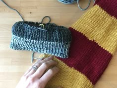 a woman is knitting on the floor with her hand next to a knitted purse