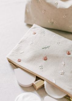 the contents of a purse sitting on top of a white tablecloth covered in buttons