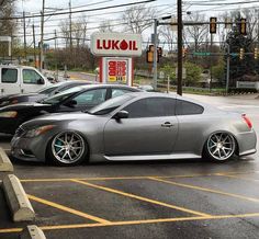 a silver sports car parked at a gas station