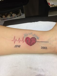 a woman's arm with a heart and heartbeat tattoo