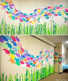 the fish are painted on the wall and grass is in front of it, along with some