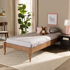 a bedroom with a bed, nightstand and plant in it