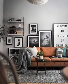 a living room filled with furniture and lots of pictures on the wall next to a coffee table