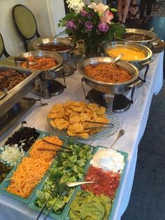 a buffet table filled with lots of different foods and dips on trays next to each other