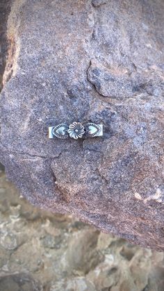 a silver ring sitting on top of a rock