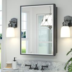 a bathroom sink with a mirror above it and lights on the wall next to it