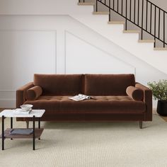 a living room with a couch, coffee table and stairs