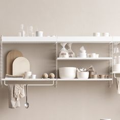 the shelves are filled with dishes and utensils