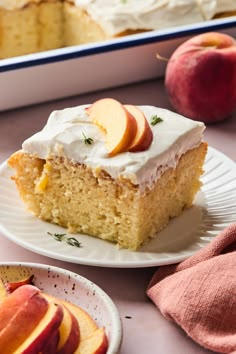 a piece of cake with white frosting and sliced peaches on plates next to it