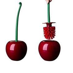 two red apples with green stems sticking out of them, one being held by a hand