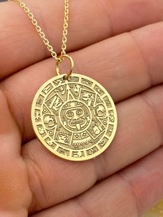 "14k Aztec Calendar Necklace, Personalized Mayan Sun Calendar Pendant, Aztec Coin Pendant, Sun Stone Aztec Calendar Necklace 14k Solid Gold Choose What Size You Want the Pendant Using The First Option Box Choose Chain Length Or Without Chain Using The Second Option Box Photos Are For The 25.4 mm / 1 Inch Diameter Pendant Pendant thickness : 0.7mm  Contact us if you want it thicker Inner diameter of jump ring : 5mm Contact us if you need it bigger  Chain width : 1.30mm     ♥  Material of pendant and chain: Solid Gold k14  ♥  Packaging: All of our jewelry are beautifully boxed and ready for gifting For more personalized designs take a look here: ♥ www.etsy.com/listing/736955132 ♥ www.etsy.com/listing/819494857 ♥ www.etsy.com/listing/823397880 ♥ www.etsy.com/listing/769847320 ♥ www.etsy.com/l Etched Necklaces For Anniversary, Etched Necklace For Anniversary, Etched Round Necklace For Anniversary, Etched Yellow Gold Round Pendant, Symbolic 14k Gold Coin Pendant Jewelry, Stamped 14k Amulet Pendant, Symbolic Engraved Round Pendant Jewelry, Symbolic Engraved Brass Jewelry, 14k Gold Etched Round Pendant Necklaces