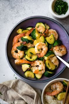 shrimp and zucchini stir fry in a bowl with chopsticks next to it