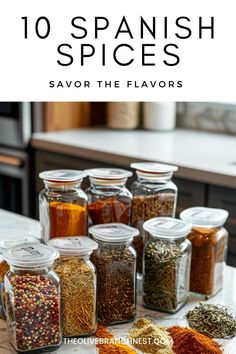 jars filled with spices sitting on top of a counter next to an oven and the words, 10 spanish spices savor the flavors