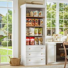 a kitchen with lots of food on the shelves in front of an open door window