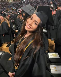 a woman in graduation gown and cap posing for the camera