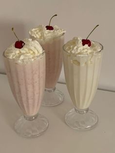 three glasses filled with ice cream and whipped cream