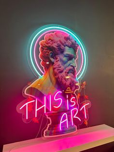 a neon sign that reads, this is art with a busture in the center