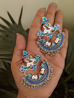 "Add charm and charisma to your beautiful personality with these exquisitely handcrafted Afghani earrings made with high quality German Silver. The intricate design and the glass enamel work renders these earrings a very unique and classy look. Pair them up with any formal or casual attire and gather compliments all the way! Weight 25gm Length 2.8\" Width 1.8\"" Silver Fusion Style Metal Danglers, Silver Metal Fusion Danglers, Silver Fusion Danglers Made Of Metal, Silver Metal Chandbalis As Gift, Silver Metal Fusion Chandbalis, Silver Fusion Style Chandbalis, Silver Meenakari Danglers, Silver Jewelry With Artistic Design For Festive Occasions, Festive Silver Jewelry With Artistic Design