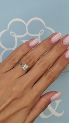 a woman's hand with pink manies and a diamond ring on her finger