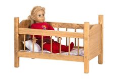 a doll is sitting in a wooden crib