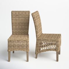 two wicker chairs sitting next to each other on a white surface with one chair facing the other