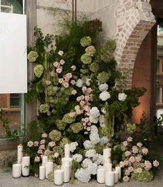 flowers and candles are arranged in front of a building