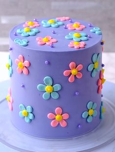 there is a purple cake with flowers on it