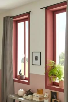 a living room with two windows and pink walls