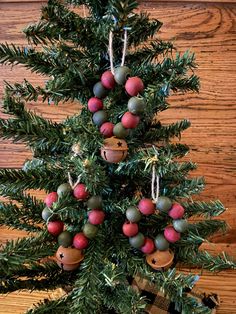 a small christmas tree with ornaments hanging from it